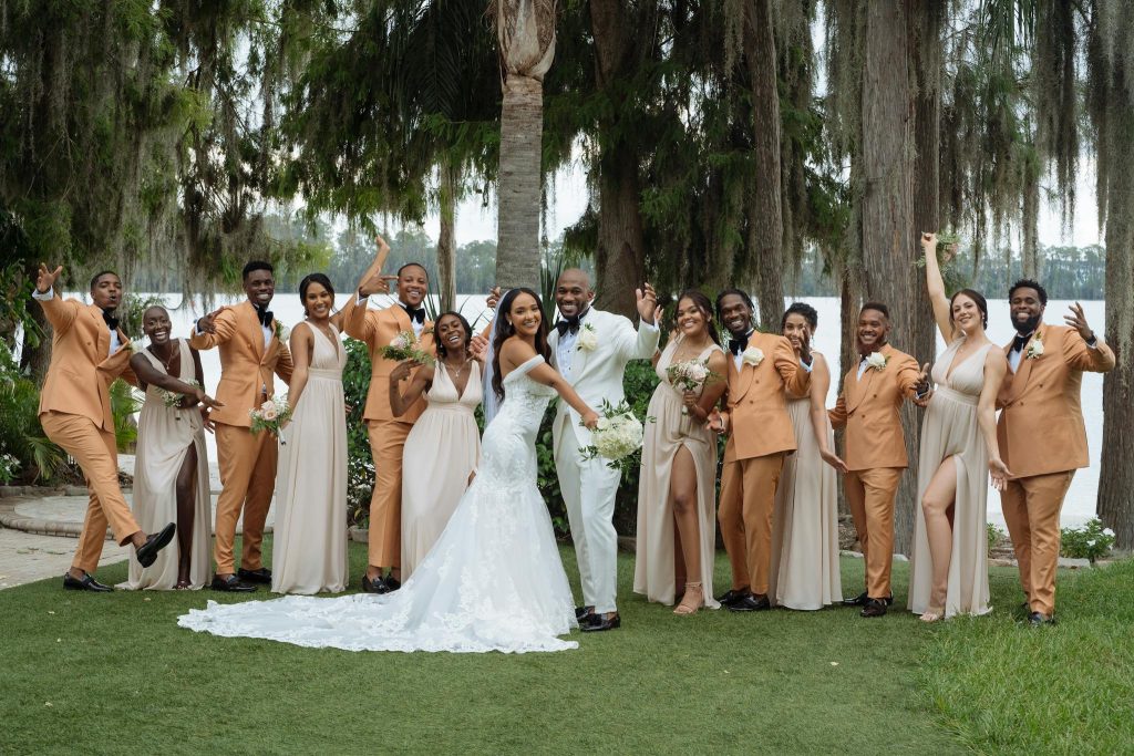 A large group celebrating at an outdoor wedding with matching attire and joyous expressions.